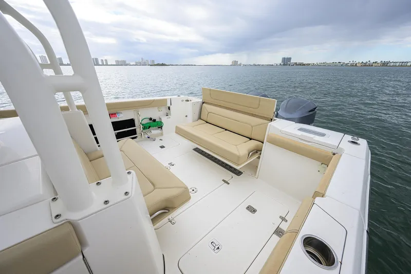 Slide: The Image of 2019 Pursuit S 328 Sport boat interior with beige seating, overlooking calm waters. - 37