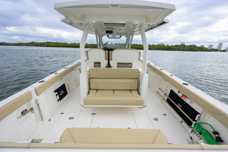 Slide: The Image of 2019 Pursuit S 328 Sport boat interior with beige seating, on calm water. - 38