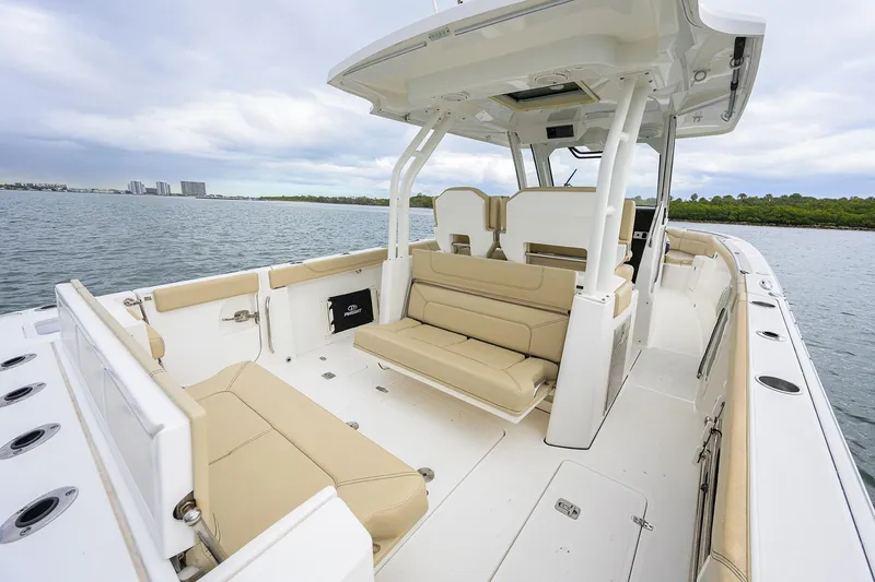 Slide: The Image of 2019 Pursuit S 328 Sport boat interior with beige seating, on calm water. - 39