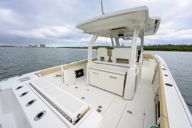Slide: The Image of 2019 Pursuit S 328 Sport boat interior with spacious deck and seating, on calm waters. - 41