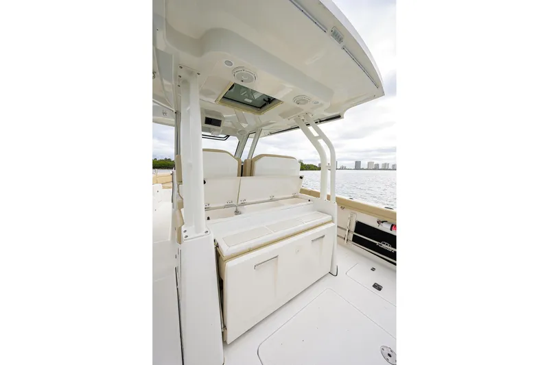 Slide: The Image of 2019 Pursuit S 328 Sport boat interior with seating and storage, overlooking water. - 44