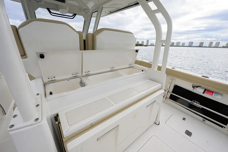 Slide: The Image of 2019 Pursuit S 328 Sport boat interior with seating and storage, overlooking waterfront skyline. - 45
