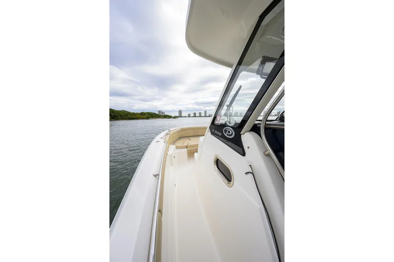 Slide: The Image of 2019 Pursuit S 328 Sport boat on water, showcasing sleek design and spacious deck. - 5