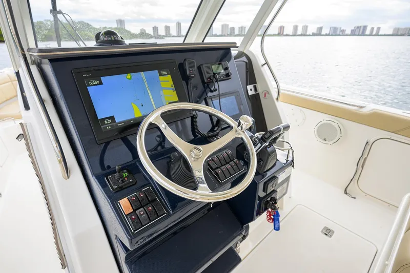 Slide: The Image of 2019 Pursuit S 328 Sport boat helm with navigation display and steering wheel. - 50