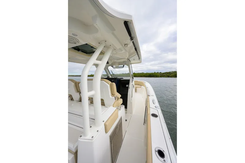 Slide: The Image of 2019 Pursuit S 328 Sport boat interior with seating and canopy on calm water. - 56