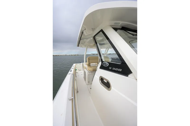 Slide: The Image of 2019 Pursuit S 328 Sport boat on water, showcasing sleek design and spacious deck. - 57