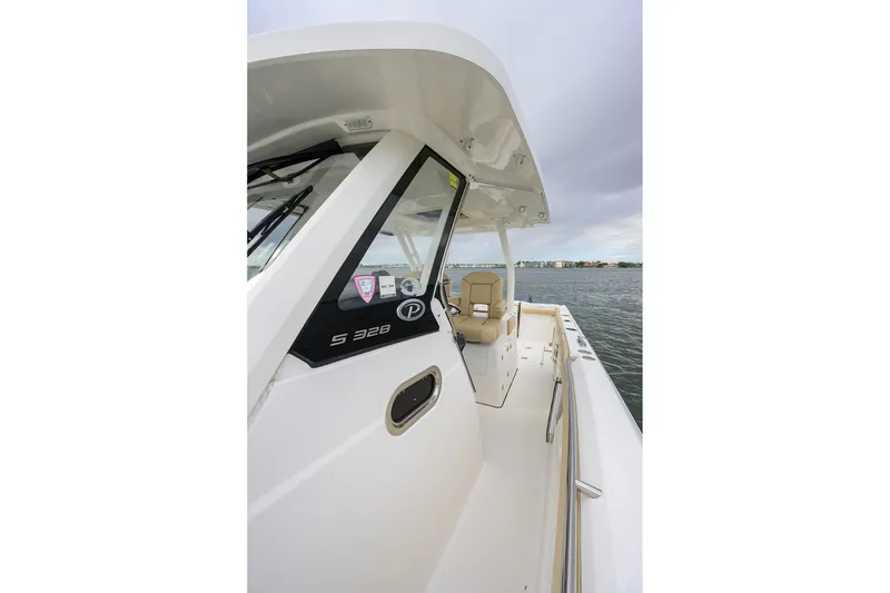 Slide: The Image of 2019 Pursuit S 328 Sport boat on water, showcasing sleek design and spacious deck. - 60