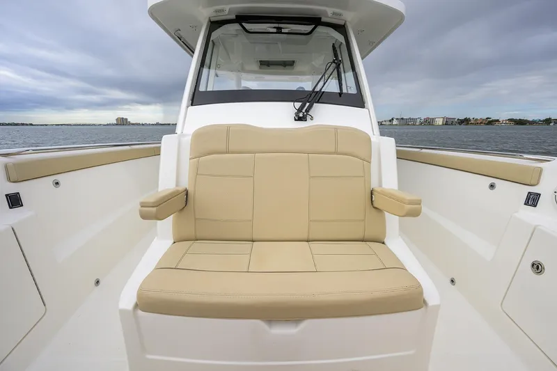 Slide: The Image of 2019 Pursuit S 328 Sport boat with beige seating, on calm waters under cloudy skies. - 9