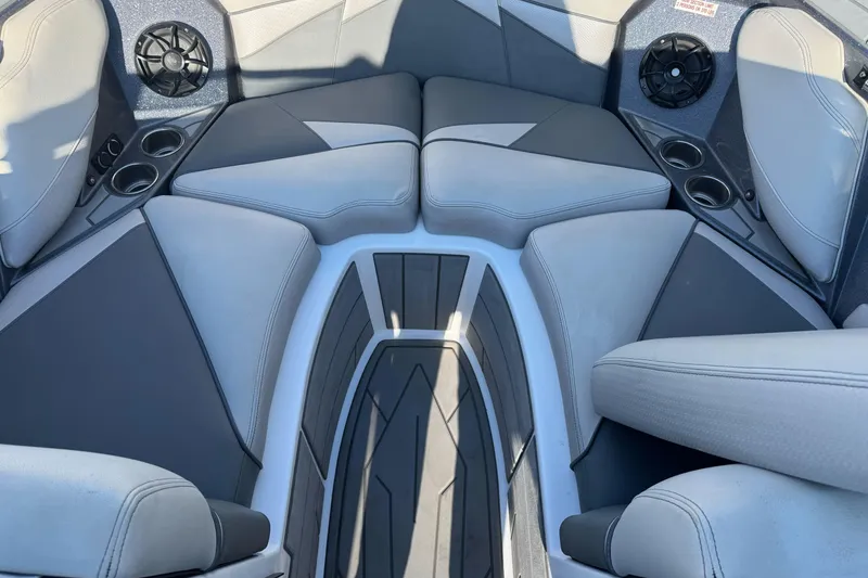 Slide: The Image of 2021 Centurion Fi23 boat interior with gray seating, cup holders, and speakers. - 14