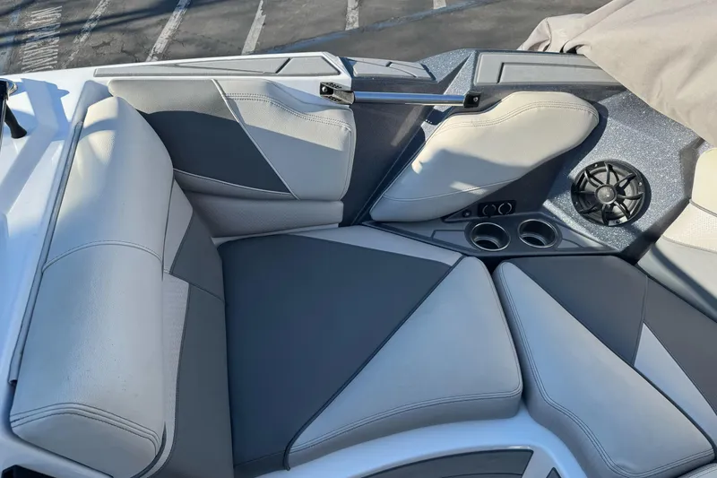 Slide: The Image of 2021 Centurion Fi23 boat interior with gray seating, cup holders, and speaker. - 15