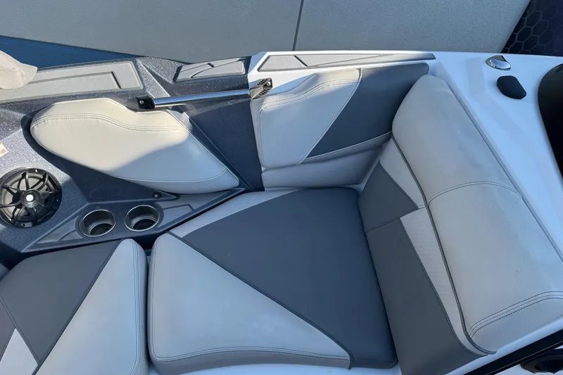 Slide: The Image of 2021 Centurion Fi23 boat interior with gray and white seating, cup holders, and speaker. - 16