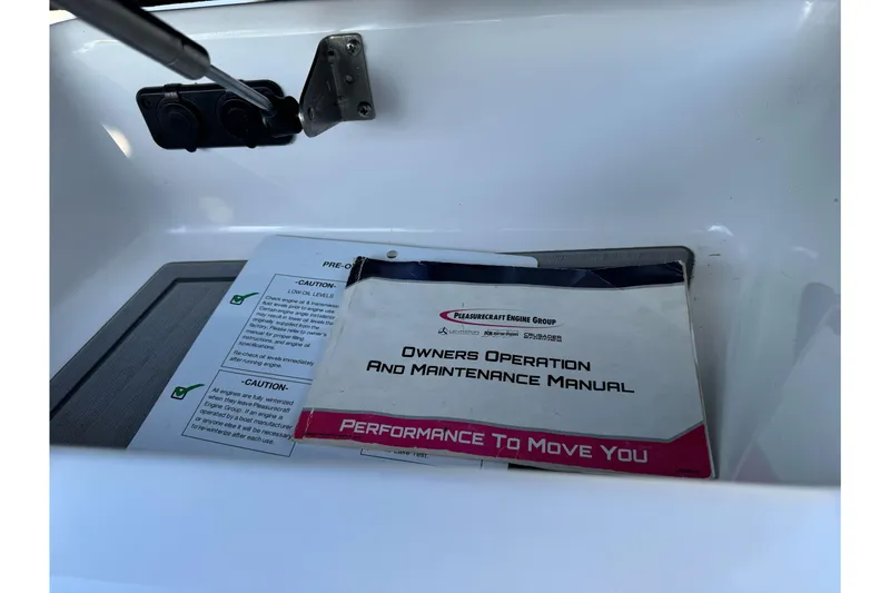 Slide: The Image of 2021 Centurion Fi23 owner's manual in a boat compartment. - 24