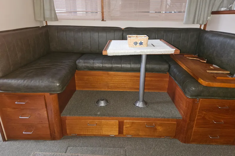 Slide: The Image of 1989 Tollycraft Sport Sedan interior with patterned sofa and wooden storage drawers. - 17