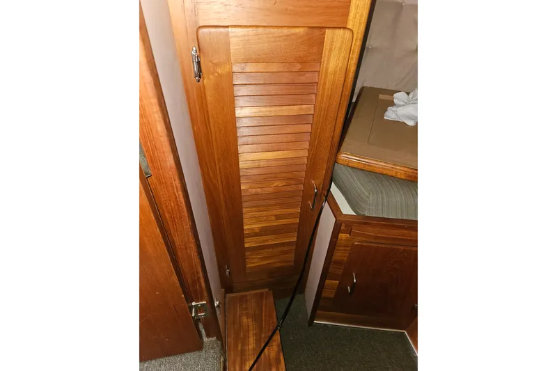 Slide: The Image of 1989 Tollycraft Sport Sedan interior with wooden cabinetry and cushioned seating. - 20