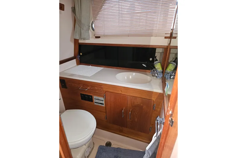 Slide: The Image of 1989 Tollycraft Sport Sedan interior with wooden cabinetry and seating area. - 21