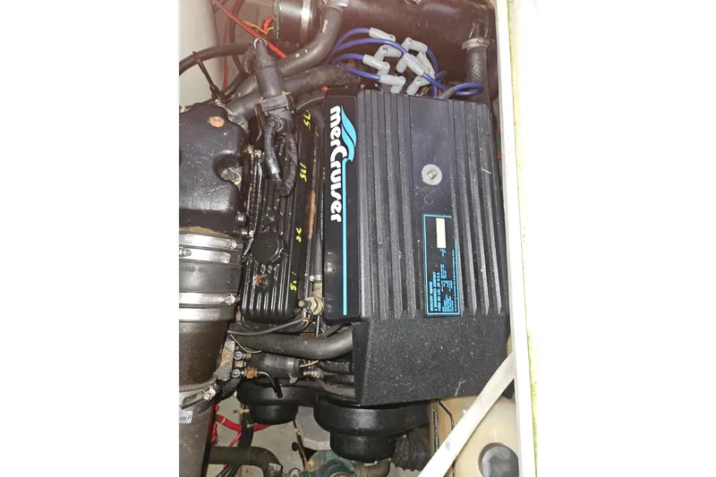 Slide: The Image of 1989 Tollycraft Sport Sedan electrical panel with wooden cabinetry and storage area. - 25