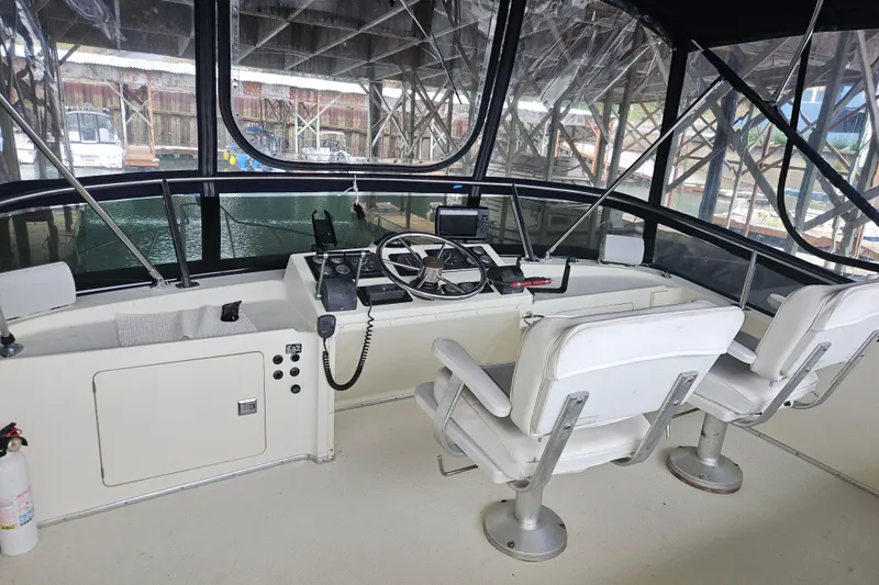 Slide: The Image of 1989 Tollycraft Sport Sedan boat with enclosed cockpit under a shelter. - 3