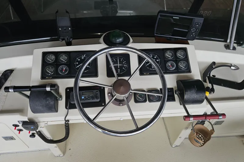 Slide: The Image of 1989 Tollycraft Sport Sedan with blue canvas enclosure under a wooden dock. - 4