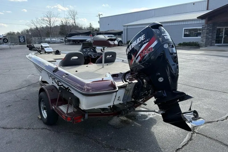 Slide: The Image of 2024 ProCraft 185 Pro boat with Evinrude engine, parked outdoors near a building. - 10