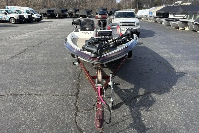 Slide: The Image of 2024 ProCraft 185 Pro boat on trailer in parking lot, surrounded by vehicles and boats. - 2