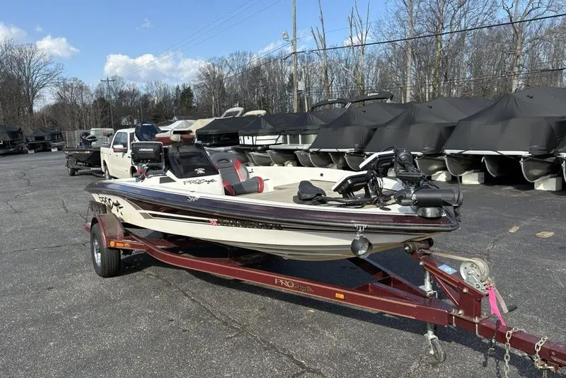 Slide: The Image of 2024 ProCraft 185 Pro boat on trailer, parked outdoors with covered boats in background. - 5