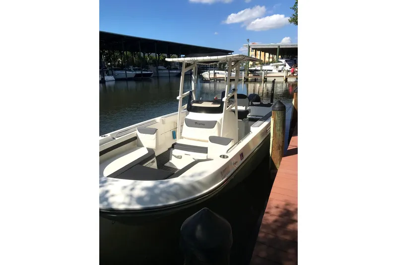 The Image of 2021 Bayliner Trophy T22CC boat docked at a marina under a clear blue sky. - 0