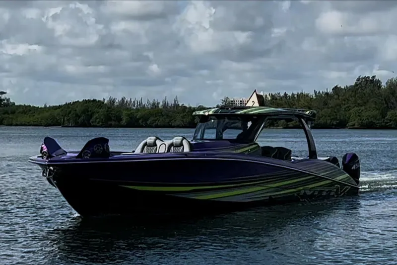 Slide: The Image of 2023 MTI 50v boat cruising on a calm lake under a cloudy sky. - 1