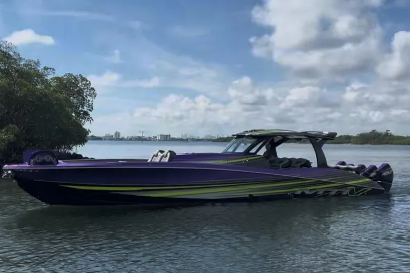 Slide: The Image of 2023 MTI 50v powerboat with sleek purple and green design on calm water. - 2