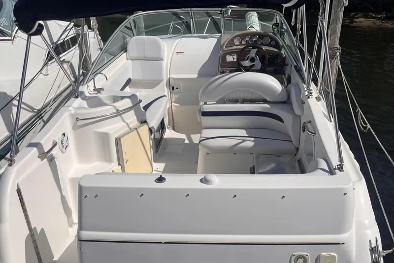 Slide: The Image of 2007 Glastron GS 279 boat interior with seating and steering wheel, docked by water. - 2