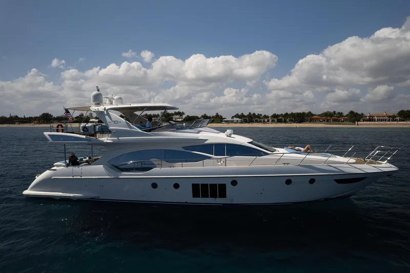 Slide: The Image of Luxury 2011 Azimut 70 yacht cruising near a scenic coastline under a partly cloudy sky. - 6