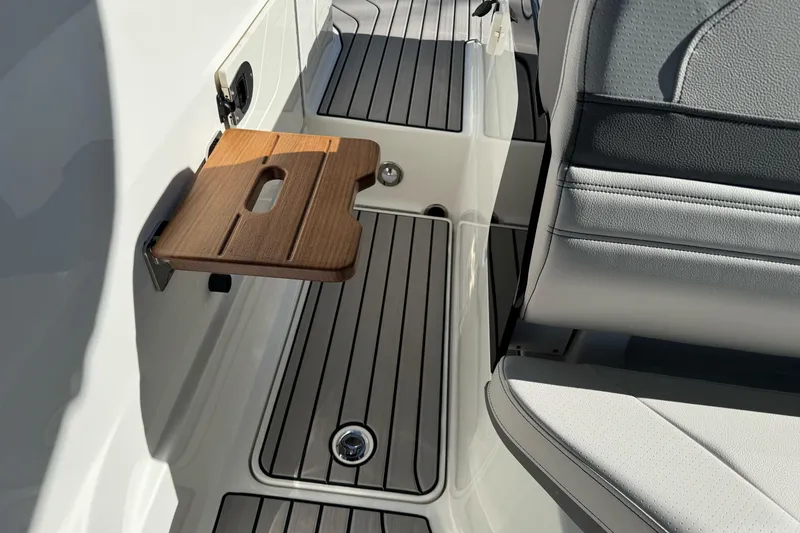 Slide: The Image of 2026 Sea Ray SLX 260 boat interior with wooden fold-out table and sleek seating. - 17