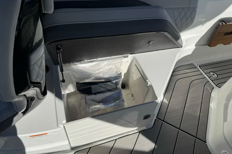 Slide: The Image of 2026 Sea Ray SLX 260 boat storage compartment with open lid, showcasing interior space. - 23
