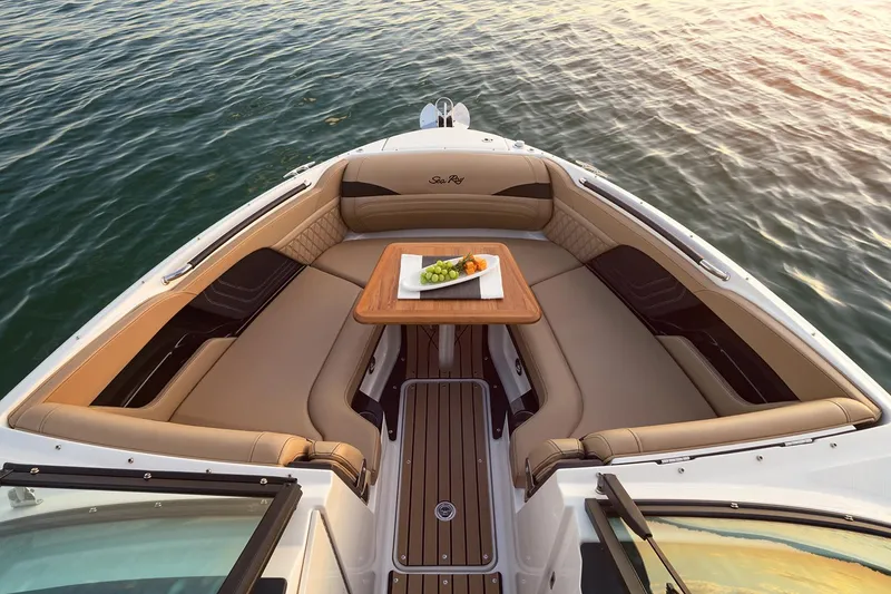 Slide: The Image of Manufacturer Provided Image: Luxurious 2025 Sea Ray SLX 260 boat interior with elegant seating and table on calm water. - 3