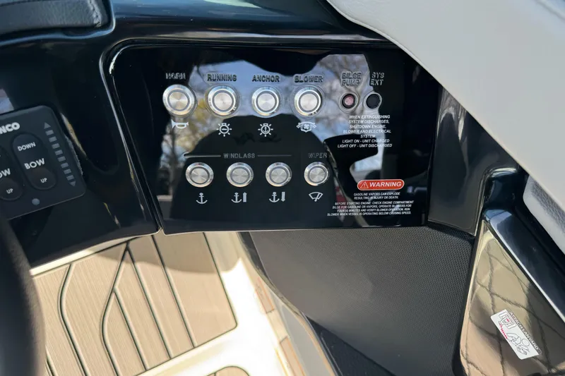 Slide: The Image of Control panel of 2026 Sea Ray SLX 260 boat with various switches and warning labels. - 37
