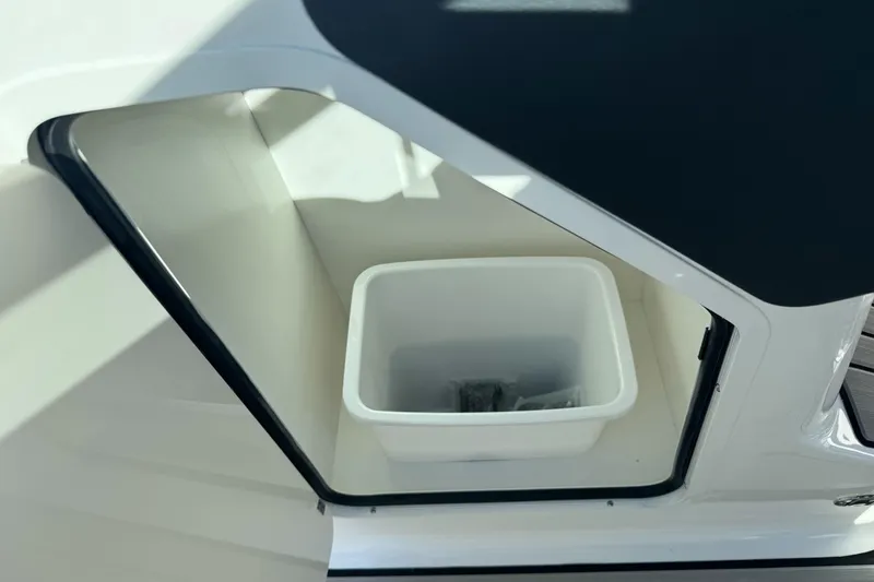 Slide: The Image of Storage compartment on 2026 Sea Ray SLX 260 boat with white container inside. - 39