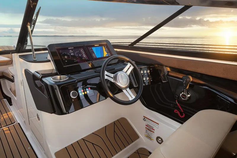 Slide: The Image of Manufacturer Provided Image: 2025 Sea Ray SLX 260 boat interior with modern dashboard and steering wheel at sunset. - 4