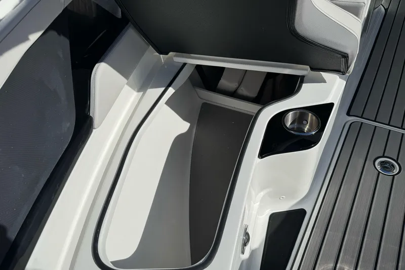 Slide: The Image of 2026 Sea Ray SLX 260 boat interior storage compartment with cup holder. - 45