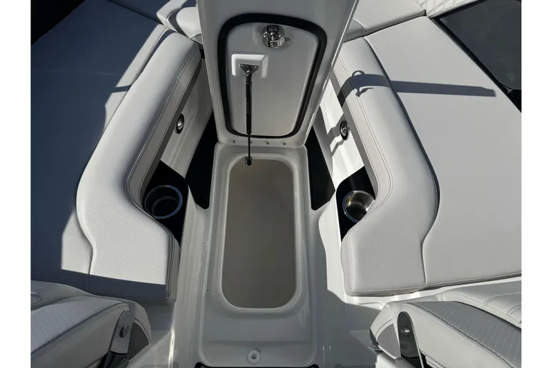 Slide: The Image of 2026 Sea Ray SLX 260 boat interior with open storage compartment and cup holders. - 50