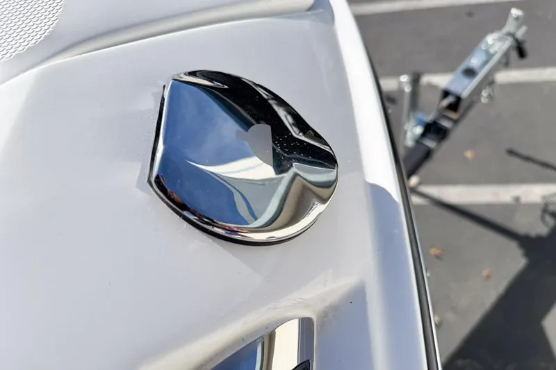 Slide: The Image of 2026 Sea Ray SLX 260 boat detail with chrome accent and trailer in background. - 42