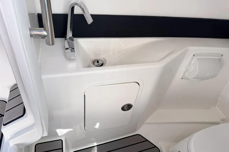 Slide: The Image of Interior of 2026 Sea Ray SLX 260 boat featuring a compact sink and storage area. - 29