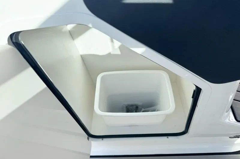Slide: The Image of Storage compartment on 2026 Sea Ray SLX 260 boat with white container inside. - 33