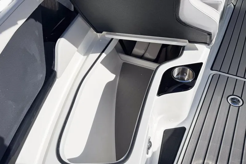 Slide: The Image of 2026 Sea Ray SLX 260 boat interior storage compartment with cup holder and sleek design. - 38