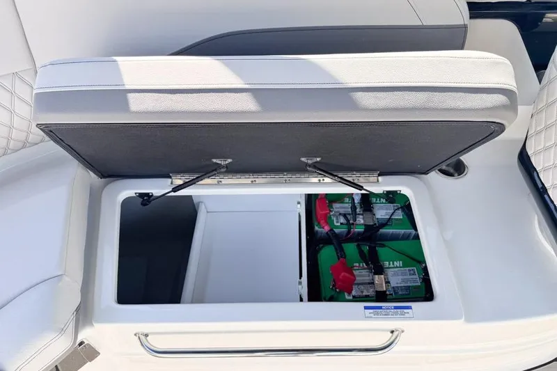 Slide: The Image of Open storage compartment on 2026 Sea Ray SLX 260 boat, revealing batteries. - 19