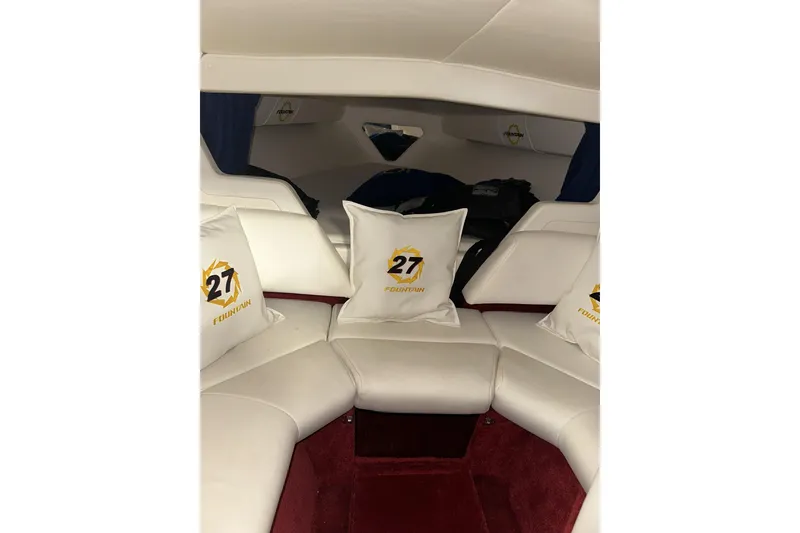 Slide: The Image of Interior of 2005 Fountain 27 Fever boat with white seating and branded pillows. - 13