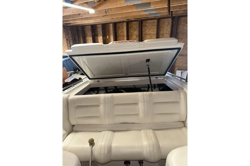Slide: The Image of 2005 Fountain 27 Fever boat interior with open engine compartment in a wooden garage. - 7