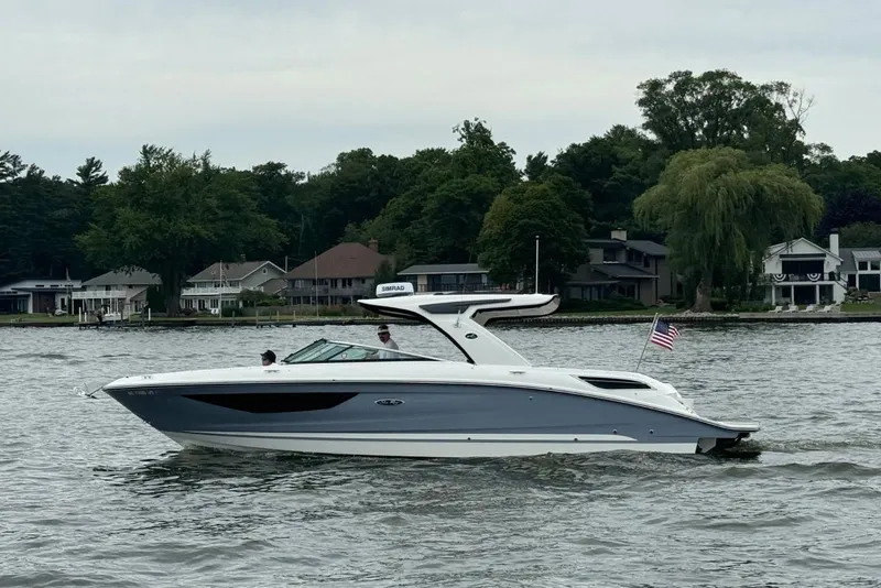 The Image of 2023 Sea Ray SLX 350 boat cruising on a lake with waterfront homes in the background. - 0