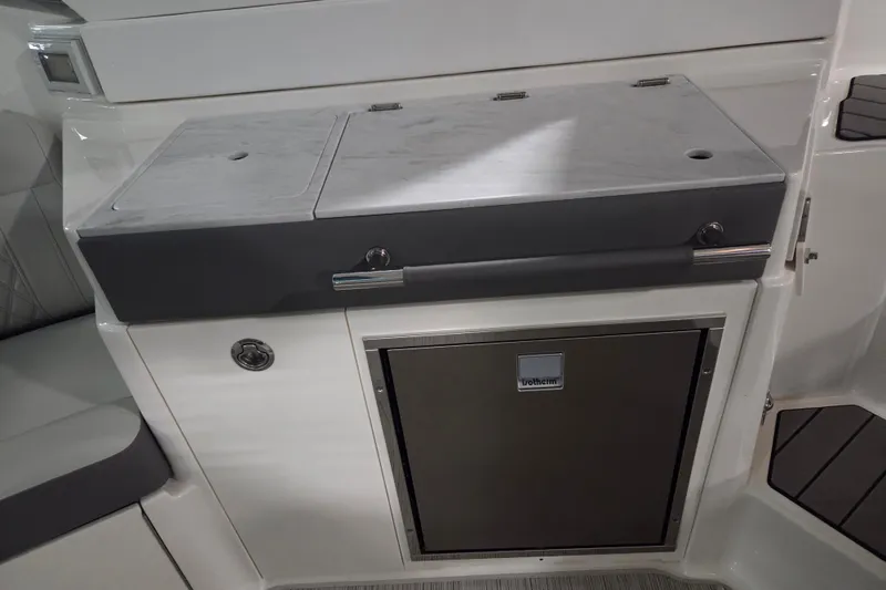 Slide: The Image of 2023 Sea Ray SLX 350 interior fridge, open door, modern design. - 26
