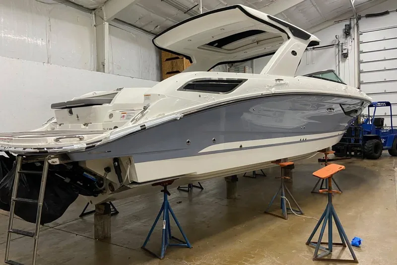 Slide: The Image of 2023 Sea Ray SLX 350 boat in a garage, elevated on stands. - 3