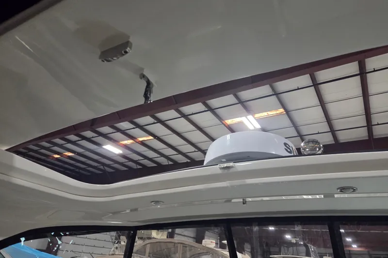 Slide: The Image of 2023 Sea Ray SLX 350 boat interior with clear windshield in a storage facility. - 54