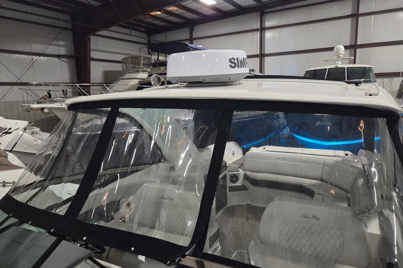 Slide: The Image of 2023 Sea Ray SLX 350 interior with blue LED lighting, speaker, and cup holders. - 56